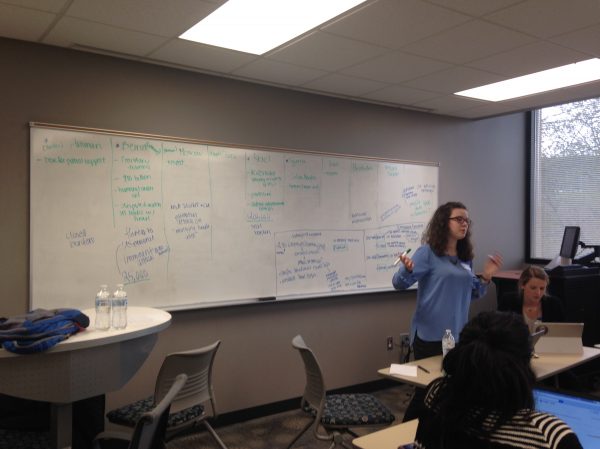 Woman speaking with white board behind